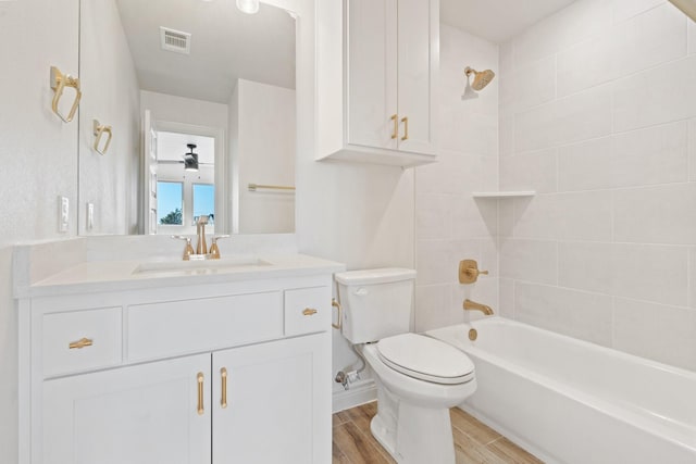 full bathroom featuring tiled shower / bath combo, toilet, and vanity