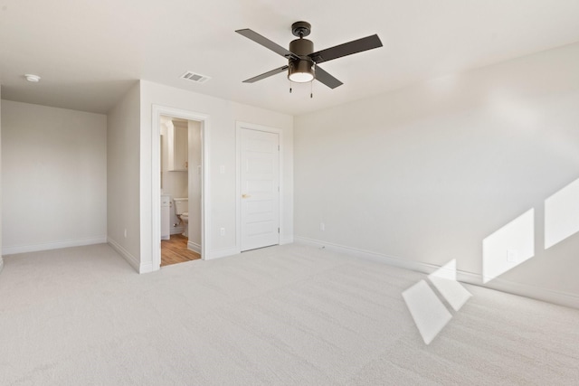 unfurnished bedroom featuring ceiling fan, connected bathroom, a closet, and light carpet