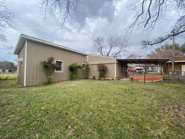 back of house with a carport and a lawn