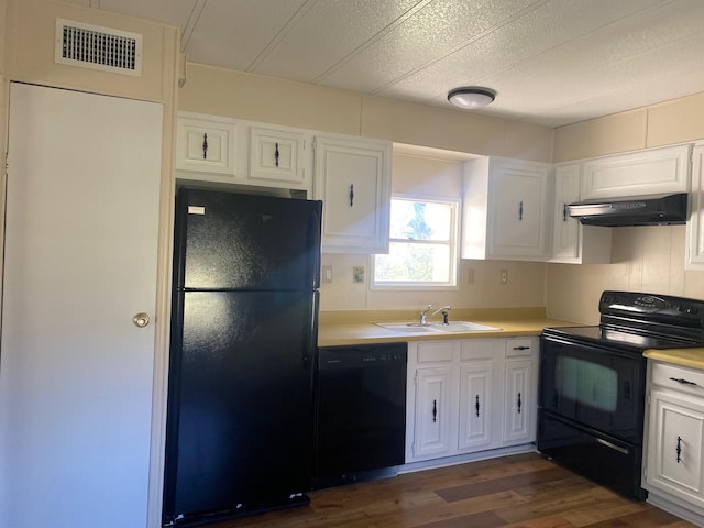 kitchen with dark hardwood / wood-style flooring, sink, black appliances, and white cabinets