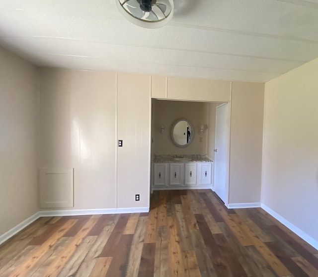 unfurnished room with dark wood-type flooring and sink