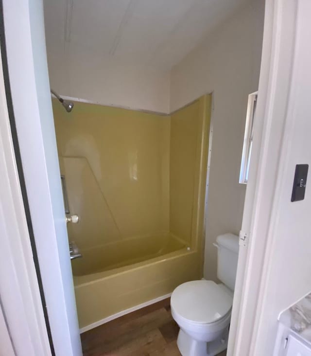 bathroom featuring hardwood / wood-style flooring, bathtub / shower combination, and toilet