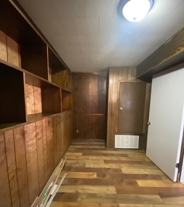 corridor featuring hardwood / wood-style flooring and wooden walls