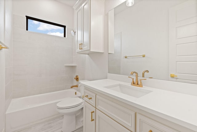 full bathroom featuring tiled shower / bath combo, toilet, and vanity