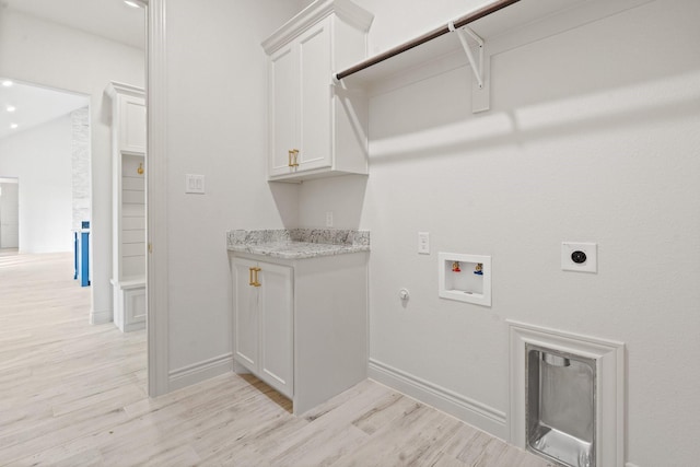 clothes washing area featuring electric dryer hookup, light wood-type flooring, hookup for a gas dryer, cabinets, and washer hookup