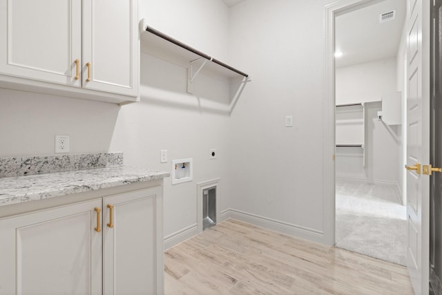 washroom featuring hookup for a washing machine, cabinets, hookup for an electric dryer, and light hardwood / wood-style floors