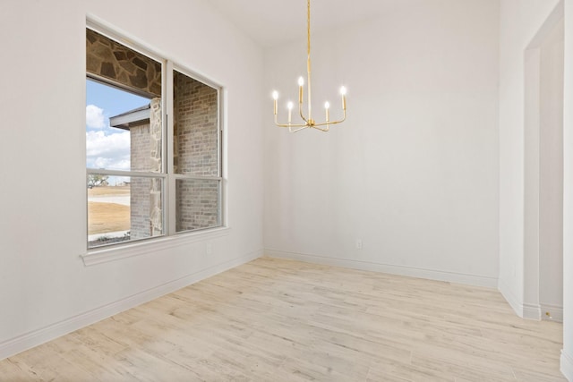 unfurnished dining area featuring a notable chandelier and light hardwood / wood-style floors