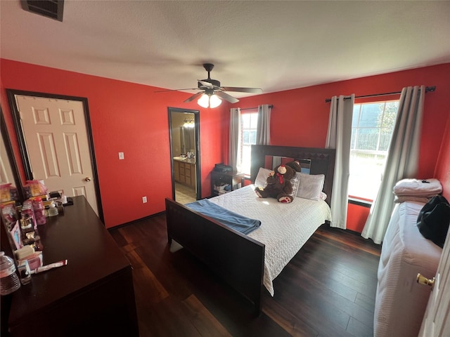 bedroom with ensuite bath, ceiling fan, and dark hardwood / wood-style flooring