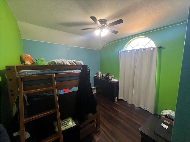 bedroom with ceiling fan, dark hardwood / wood-style flooring, and lofted ceiling