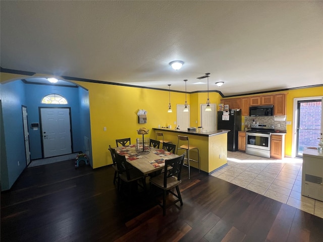 dining area with light wood-type flooring and ornamental molding