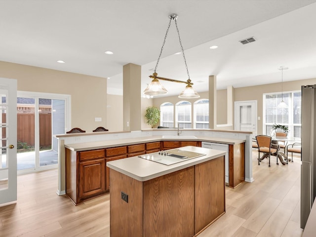 kitchen with a center island, sink, decorative light fixtures, kitchen peninsula, and electric stovetop