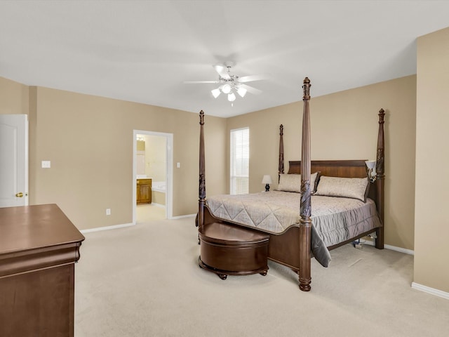 bedroom featuring light carpet, ensuite bathroom, and ceiling fan