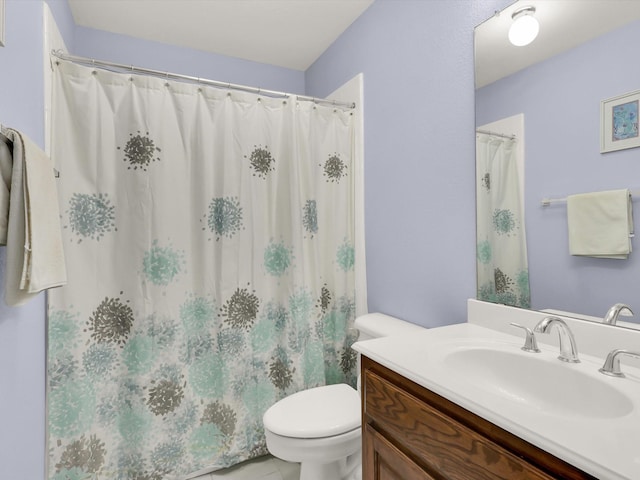 bathroom with tile patterned flooring, vanity, and toilet