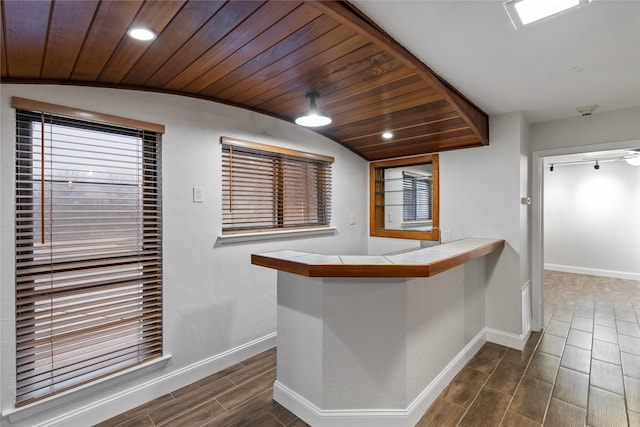 kitchen featuring tile countertops, lofted ceiling, wooden ceiling, a kitchen breakfast bar, and kitchen peninsula