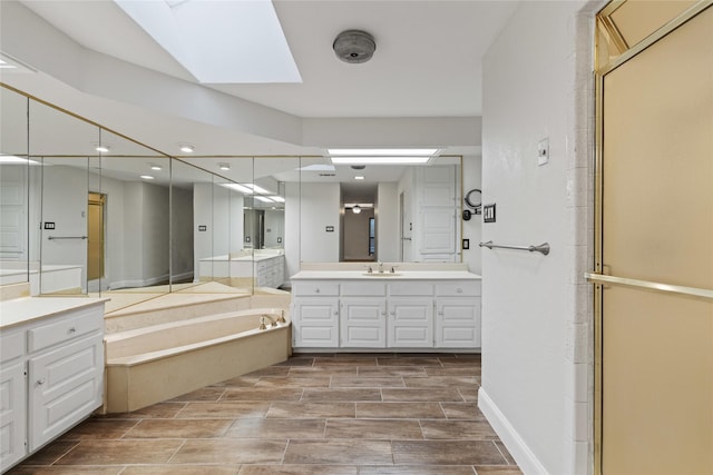 bathroom featuring vanity, a skylight, and separate shower and tub