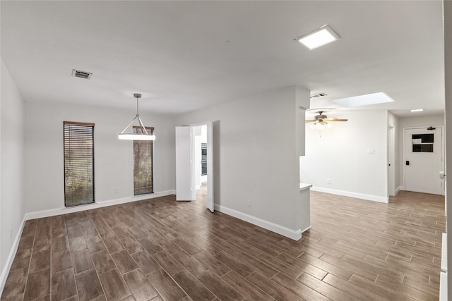 unfurnished living room with a skylight and ceiling fan