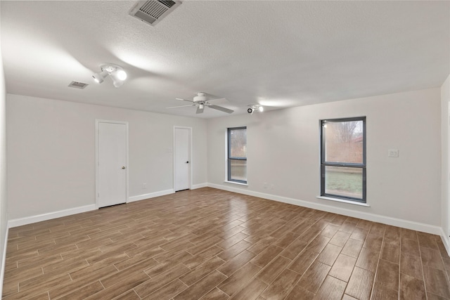 empty room with ceiling fan and a textured ceiling