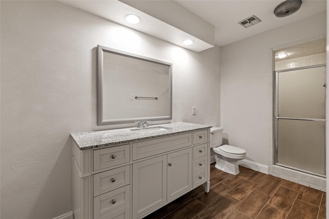 bathroom featuring vanity, toilet, and an enclosed shower