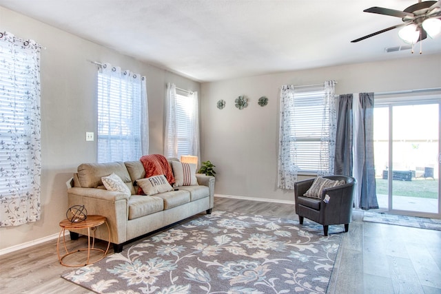 living room with ceiling fan, a healthy amount of sunlight, and light hardwood / wood-style flooring