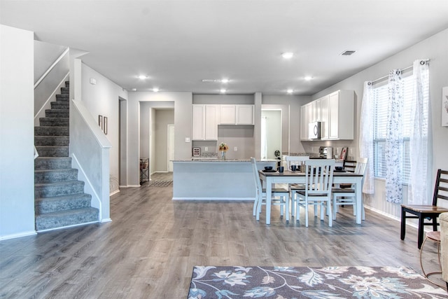 kitchen featuring white cabinetry, light stone counters, and light hardwood / wood-style floors