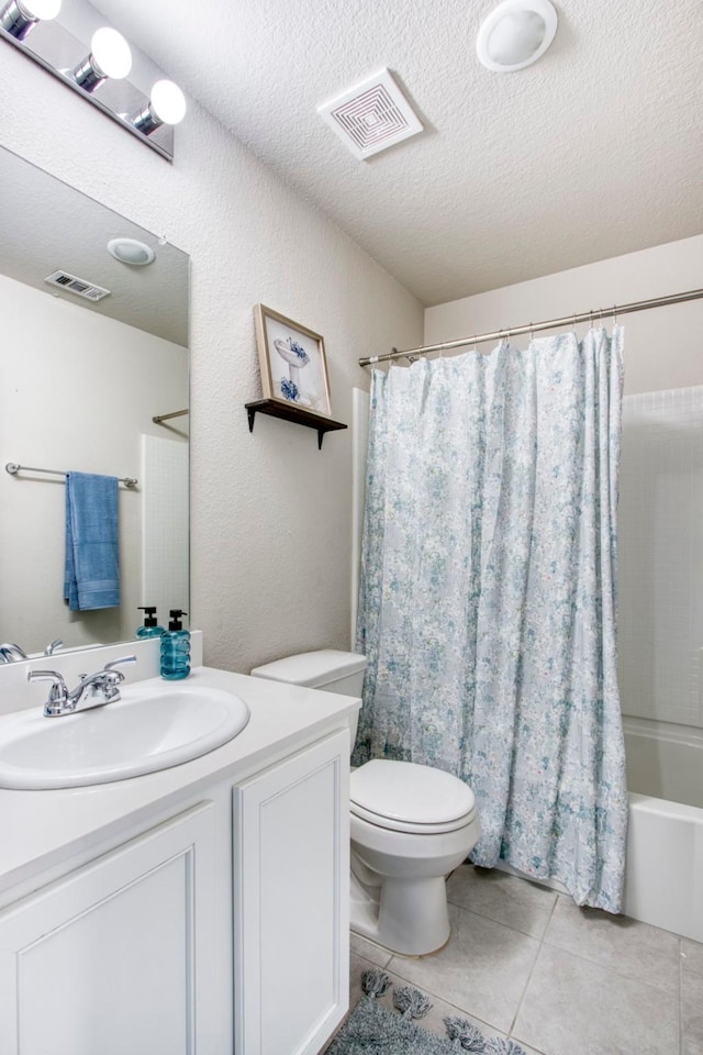 full bathroom featuring tile patterned floors, toilet, a textured ceiling, vanity, and shower / bath combo with shower curtain