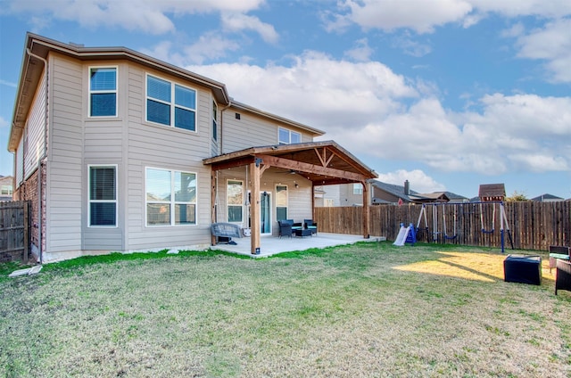 rear view of house featuring a yard and a patio