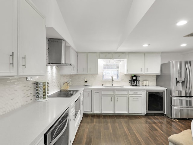 kitchen featuring sink, beverage cooler, wall chimney range hood, black electric stovetop, and stainless steel fridge