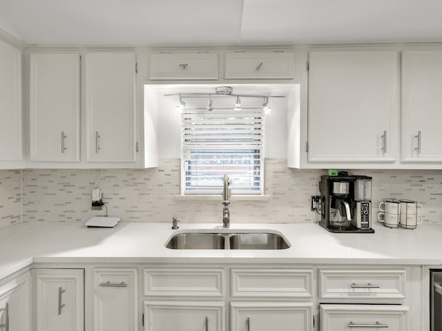 kitchen with sink, tasteful backsplash, and white cabinetry