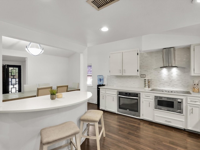 kitchen featuring wall chimney exhaust hood, stainless steel appliances, and white cabinets