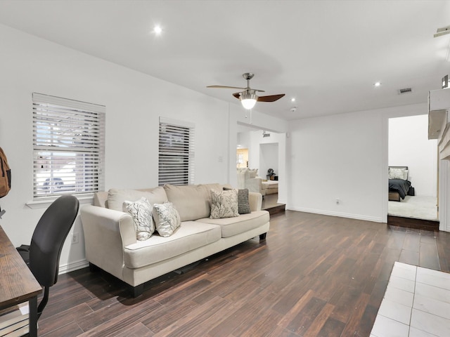 living room featuring ceiling fan and dark wood-type flooring