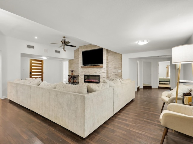 living room featuring a fireplace, dark wood-type flooring, and ceiling fan