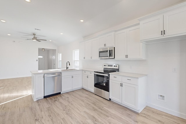 kitchen with white cabinets, stainless steel appliances, kitchen peninsula, and ceiling fan