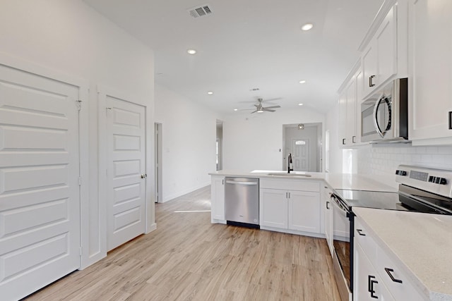 kitchen with white cabinets, sink, ceiling fan, appliances with stainless steel finishes, and kitchen peninsula