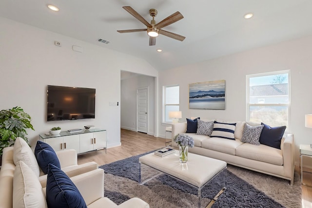 living room featuring ceiling fan, vaulted ceiling, and light wood-type flooring