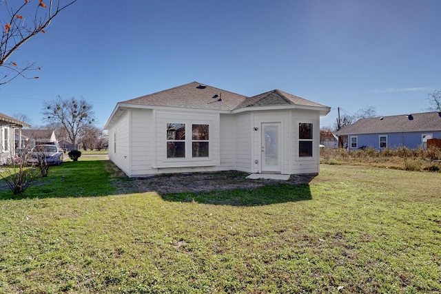 rear view of house featuring a yard