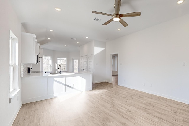 interior space with ceiling fan, sink, and light hardwood / wood-style flooring