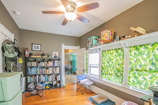 sitting room featuring ceiling fan, wood-type flooring, and washer and dryer