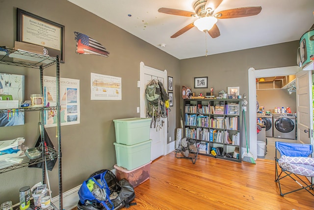 miscellaneous room with ceiling fan, independent washer and dryer, and wood-type flooring