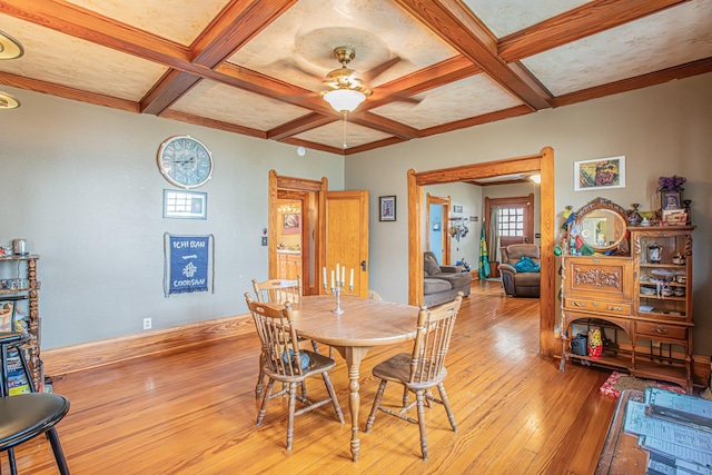 dining area with beam ceiling, ceiling fan, coffered ceiling, and light hardwood / wood-style floors