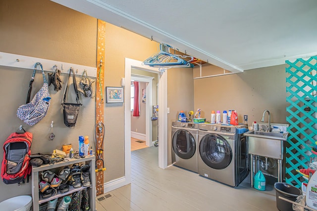 laundry area featuring washer and clothes dryer and light hardwood / wood-style floors