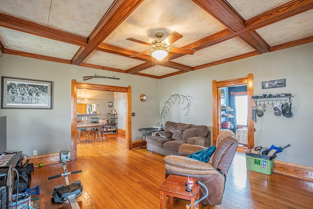 living room featuring beam ceiling, ceiling fan, light hardwood / wood-style flooring, and coffered ceiling