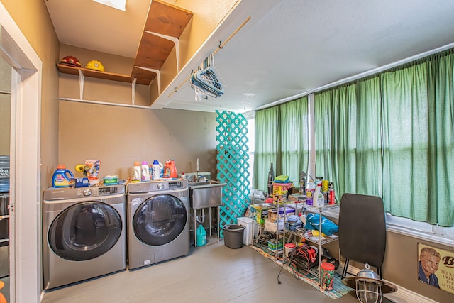 laundry room featuring washer and dryer, sink, and light hardwood / wood-style flooring