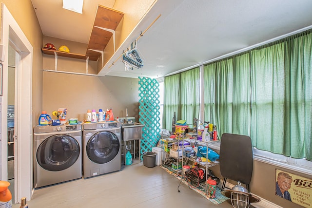 laundry area featuring washing machine and clothes dryer and light hardwood / wood-style flooring