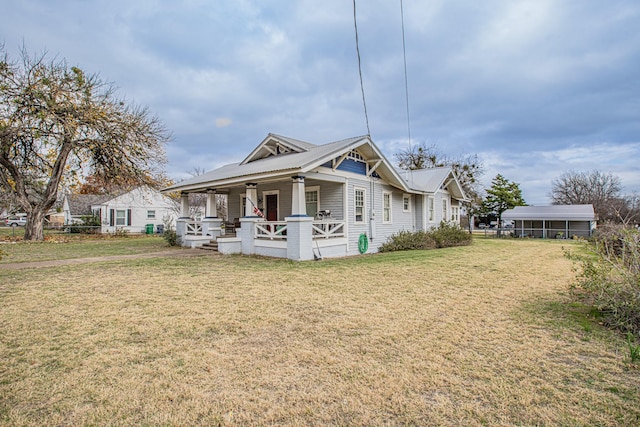 view of front of home featuring a carport, a front yard, and covered porch