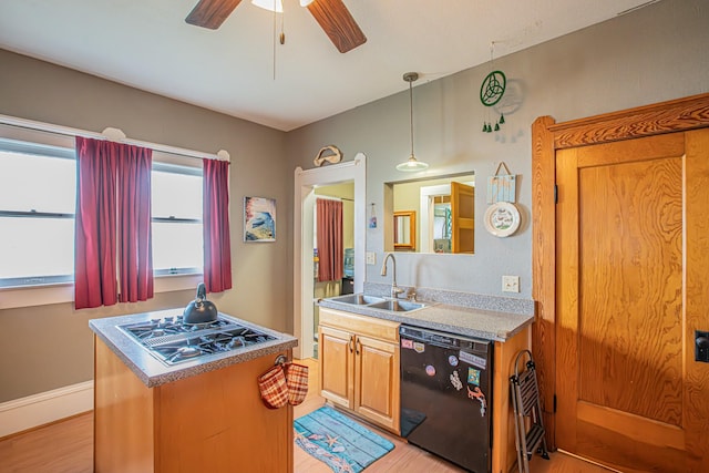 kitchen featuring pendant lighting, stainless steel gas stovetop, dishwasher, sink, and light hardwood / wood-style flooring