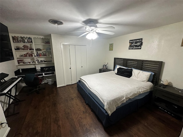 bedroom featuring dark hardwood / wood-style floors, a textured ceiling, ceiling fan, and a closet