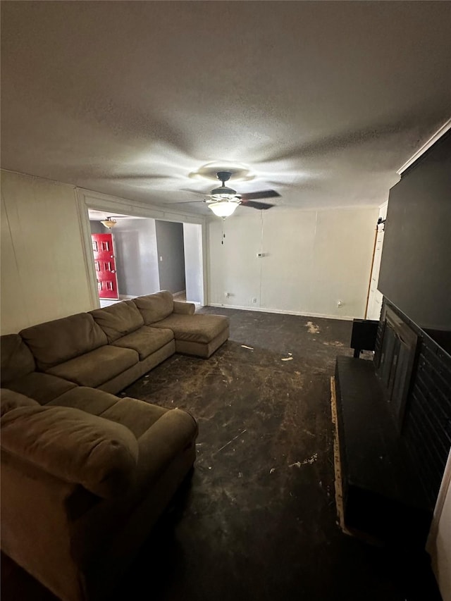 living room featuring ceiling fan and a textured ceiling