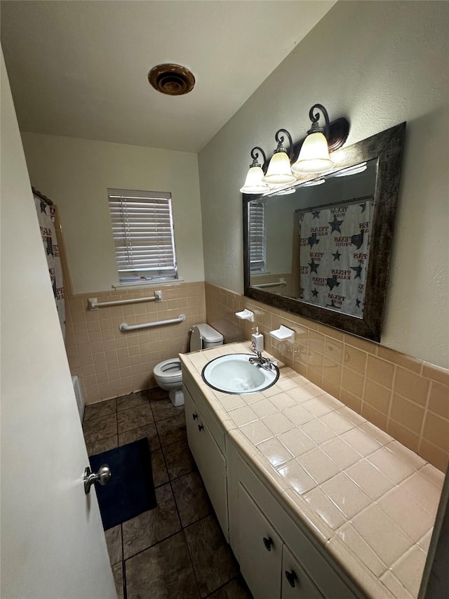 bathroom with tile patterned flooring, vanity, tile walls, and toilet