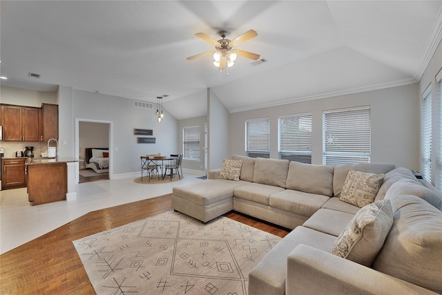 living room featuring light hardwood / wood-style flooring, ceiling fan, lofted ceiling, and crown molding