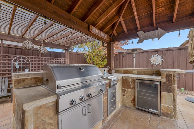 view of patio / terrace with an outdoor kitchen, wine cooler, and a grill